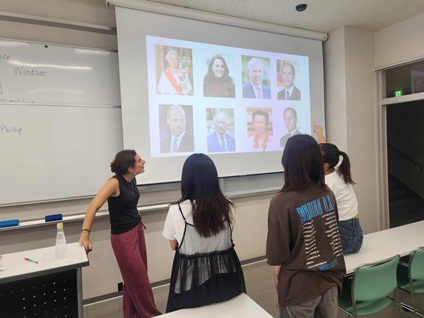 スクリーンの前でディスカッションする大学生