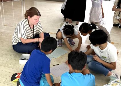 子どもたちと絵を描いて遊ぶ大学生